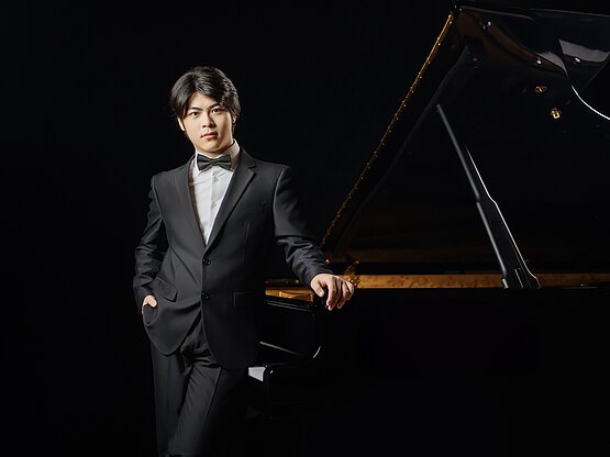 Felix Hua vor einem Klavier